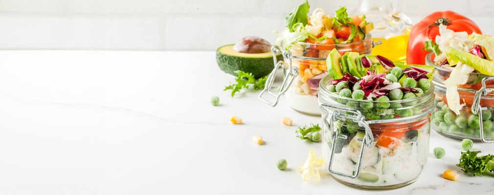 Cucina vegana Immagine d'atmosfera: barattoli di metallo pieni di pasti vegani