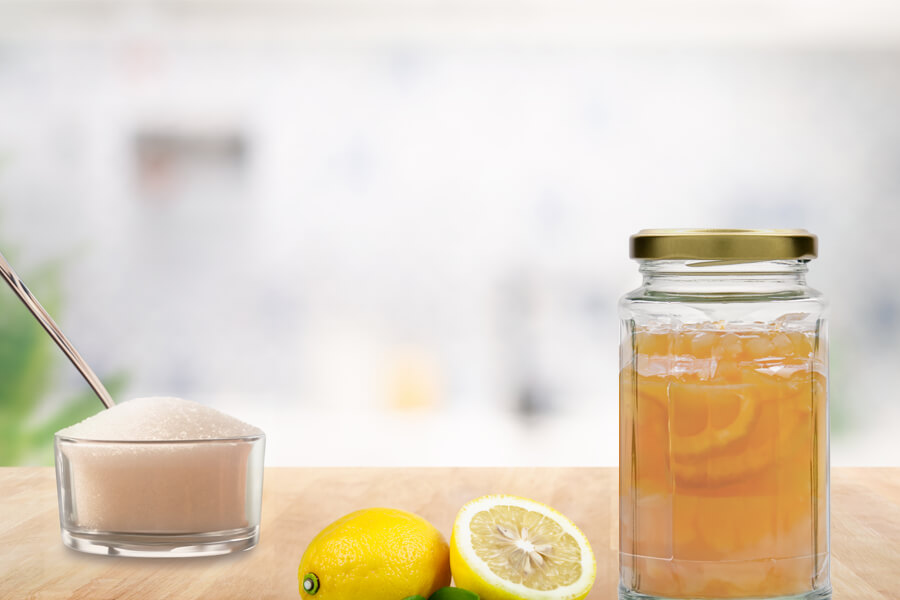 marmellata di limone Immagine d'atmosfera: barattolo di conserva pieno di marmellata di limoni, disposto accanto a un limone a fette e una zuccheriera