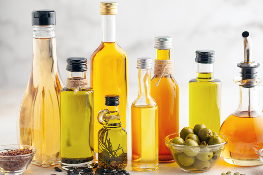 bottiglie di olio riempite Immagine d'atmosfera: gruppo di bottiglie piene di olio di varie dimensioni e forme, disposte con olive e spezie