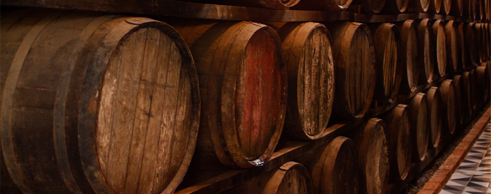 fermentazione alcolica Banner informativo: le botti per la conservazione dell'alcol sono accatastate in più file in una cantina