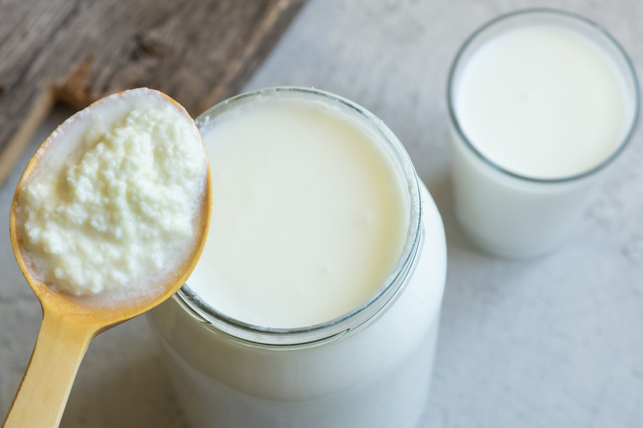 Alimenti omogeneizzati Guida "Omogeneizzato": due bicchieri di latte e un cucchiaio di legno con la cagliata