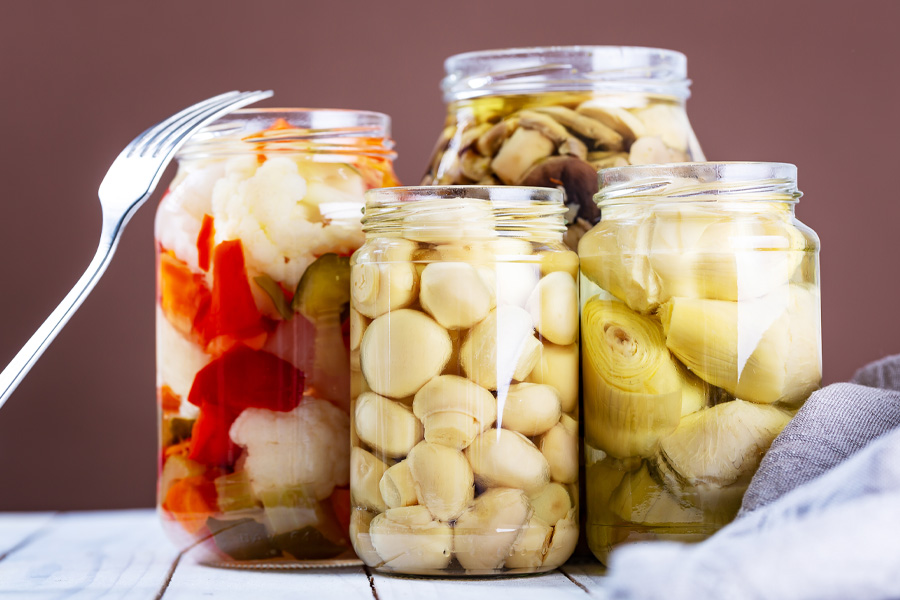 Vasetti di verdure sottaceto Immagine d'atmosfera: barattoli con funghi, carciofi e altre verdure sott'aceto