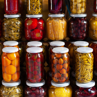 Immagine d'atmosfera: barattoli impilati con frutta e verdura in salamoia