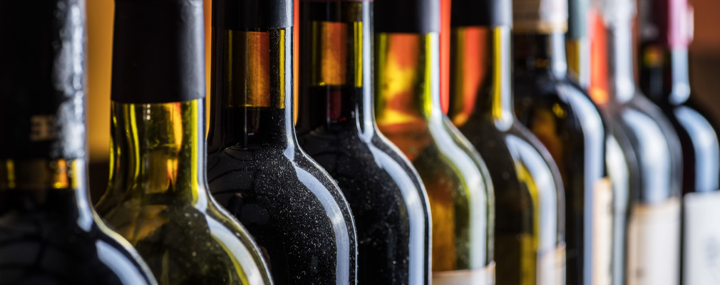 Immagine d'atmosfera: un'intera fila di bottiglie di vino diverse