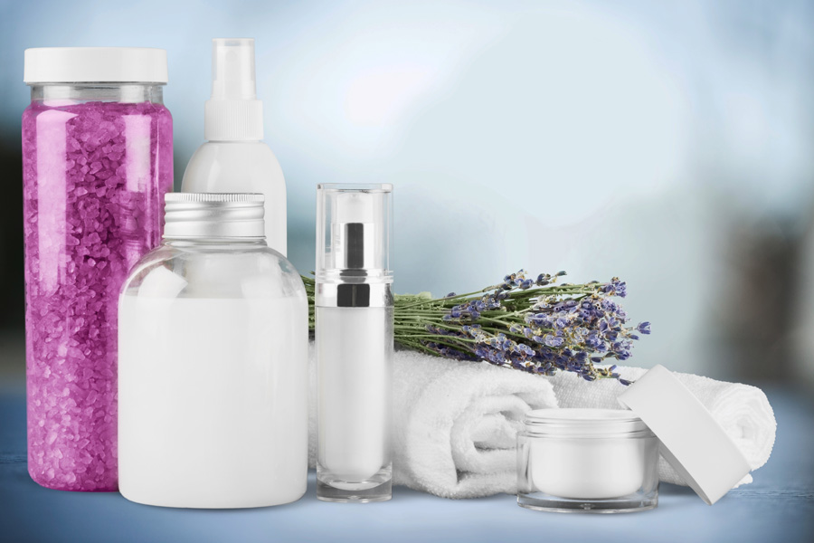 Immagine d'atmosfera: diversi contenitori per cosmetici di forme diverse accanto a due asciugamani