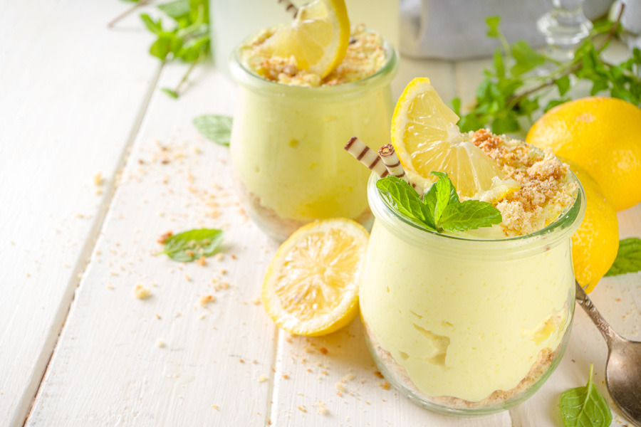 Ricetta Torta in barattolo Immagine d'atmosfera: torta con crema al limone in un bicchiere decorato con menta e limoni