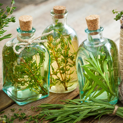 Olio aromatizzato Tre bottiglie di vetro trasparente riempite con olio aromatizzato, chiuse con un tappo di sughero