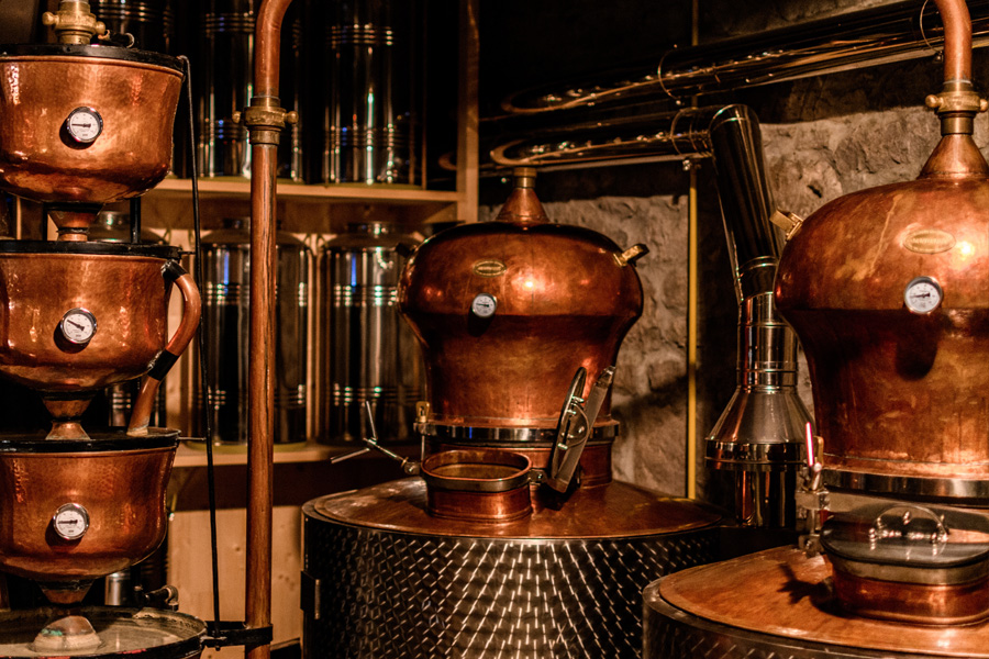 Dispositivi per la fermentazione alcolica Immagine d'atmosfera: grandi bollitori di rame per la distillazione dell'alcol in una distilleria