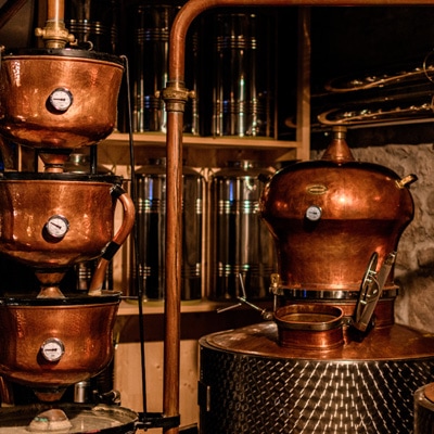 Atmosfera: grandi bollitori di rame per la distillazione dell'alcol in una distilleria – vista mobile